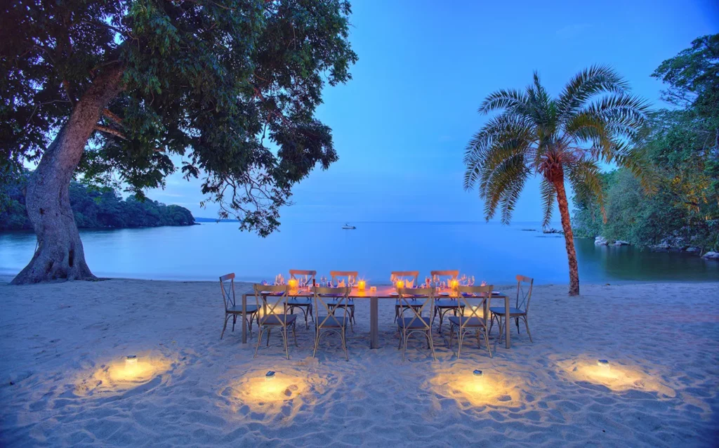 Table on the beach set for dinner on the shores of Lake Victoria at Rubondo Island