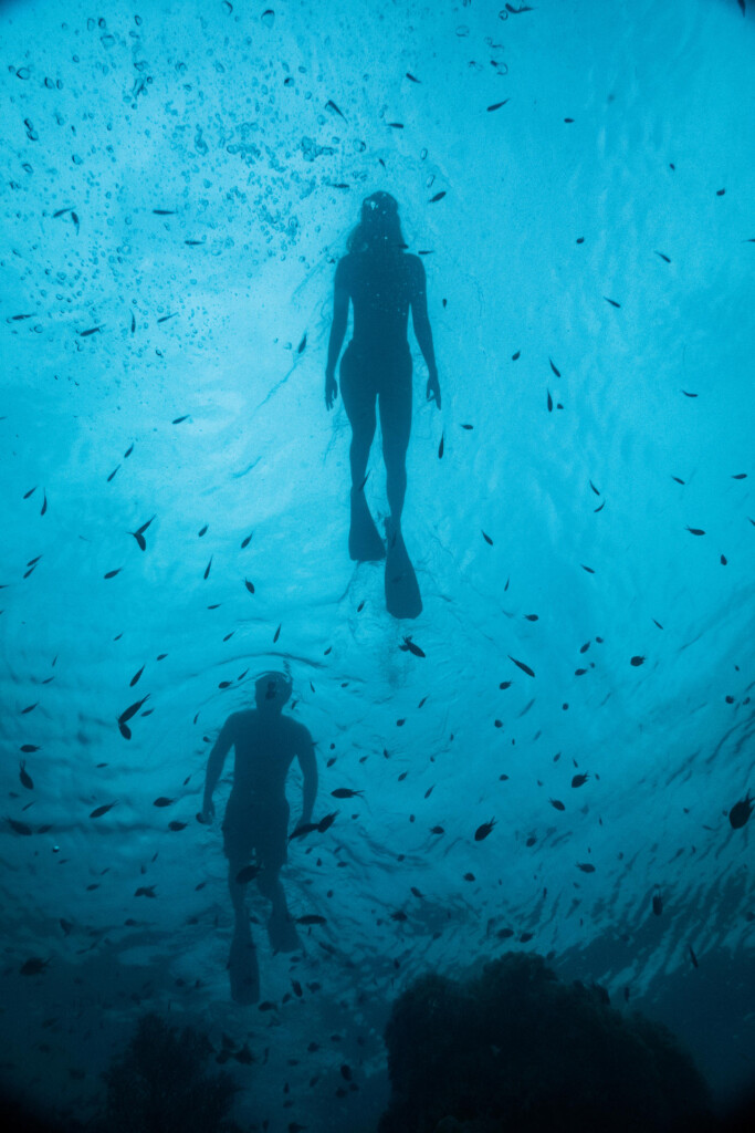 Fanjove island, scuba divers ascending from the big blue sea